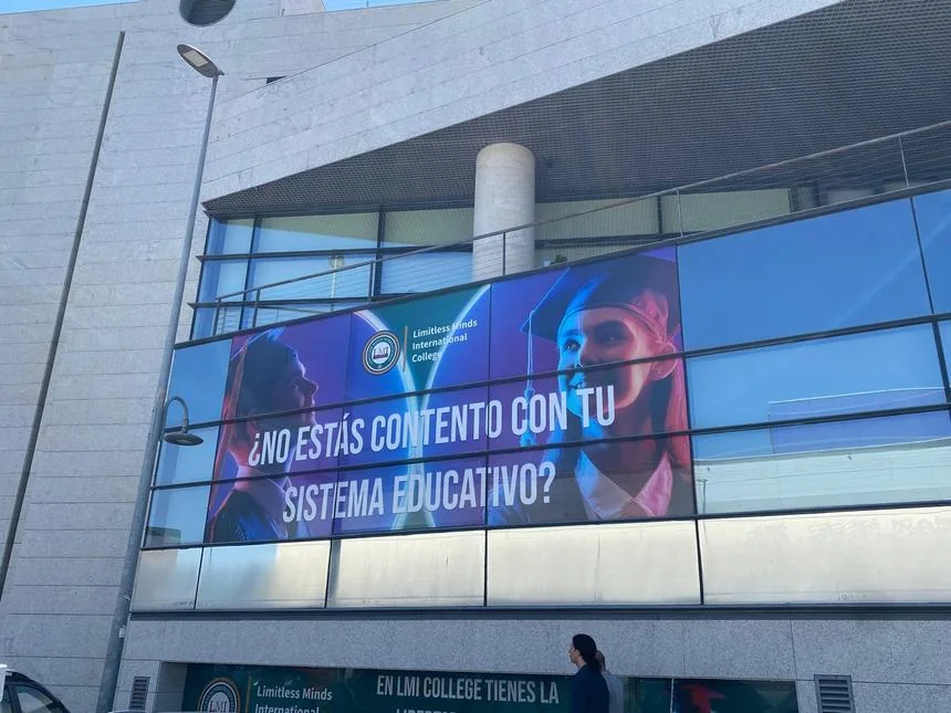 Lona publicitaria de gran formato en fachada de edificio.