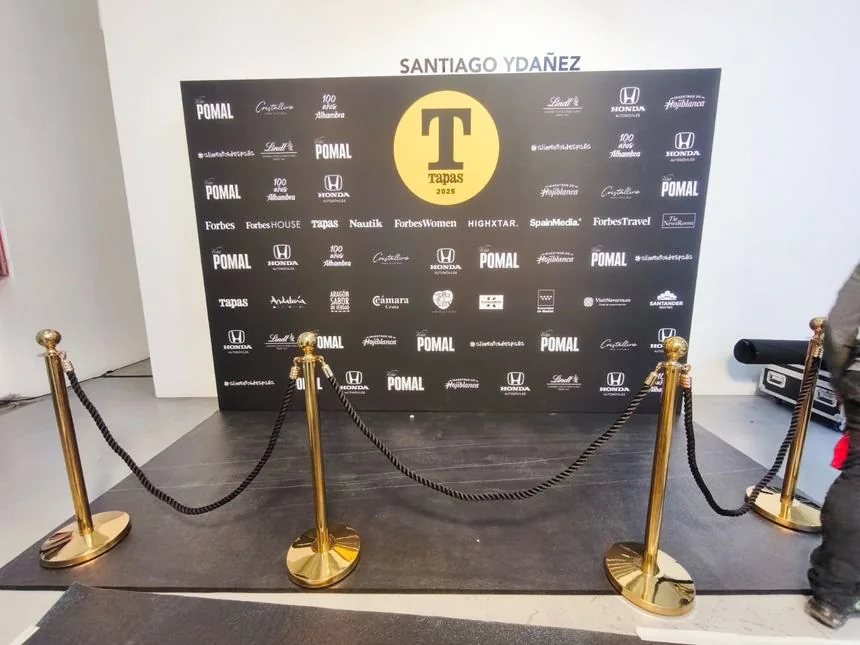 Photocall de alfombra roja con vallas para evento.