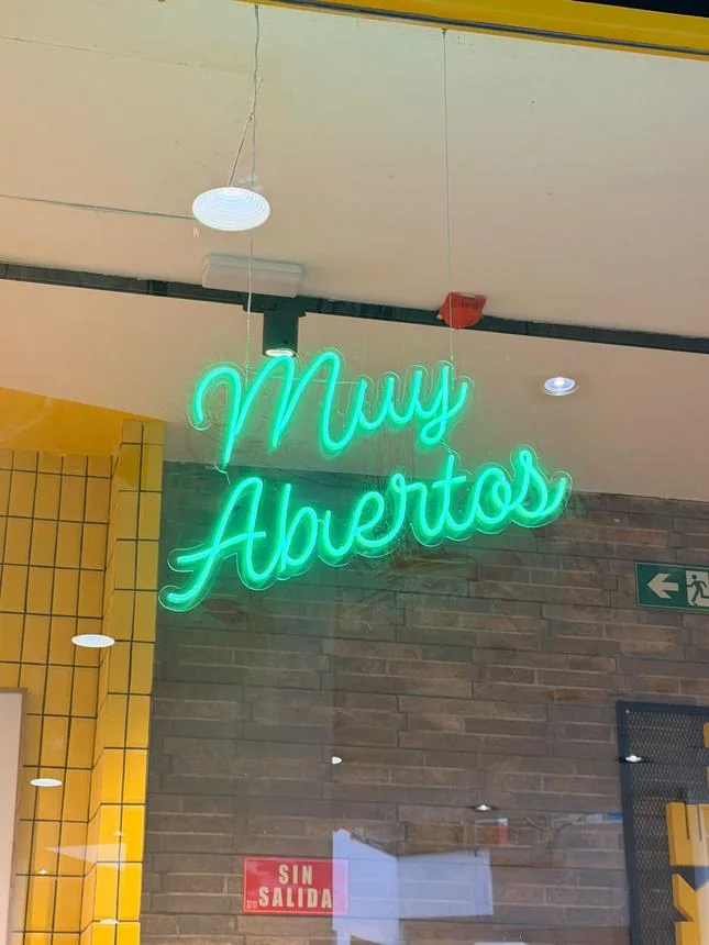 Rótulo de neón «Muy Abiertos» para escaparate comercial.